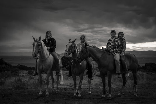Riders on horseback in black and white