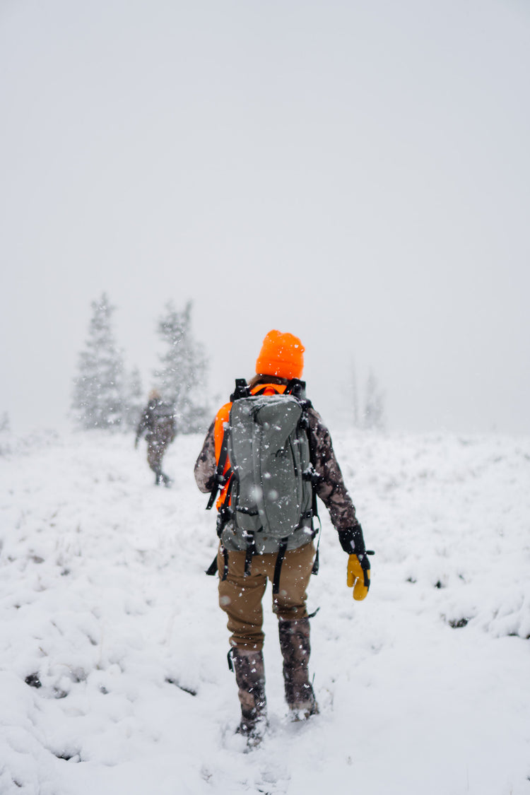 Hunters walking through falling snow