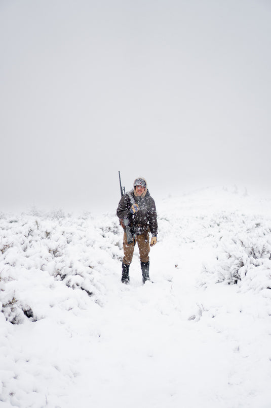 Hunter walking alone through deep snow